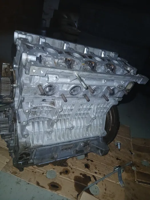 A bare engine block standing on cardboard in the workshop
